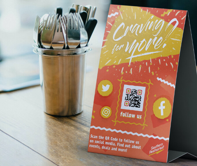Table tent at a restaurant with a QR Code that links to all their social media channels on one page.