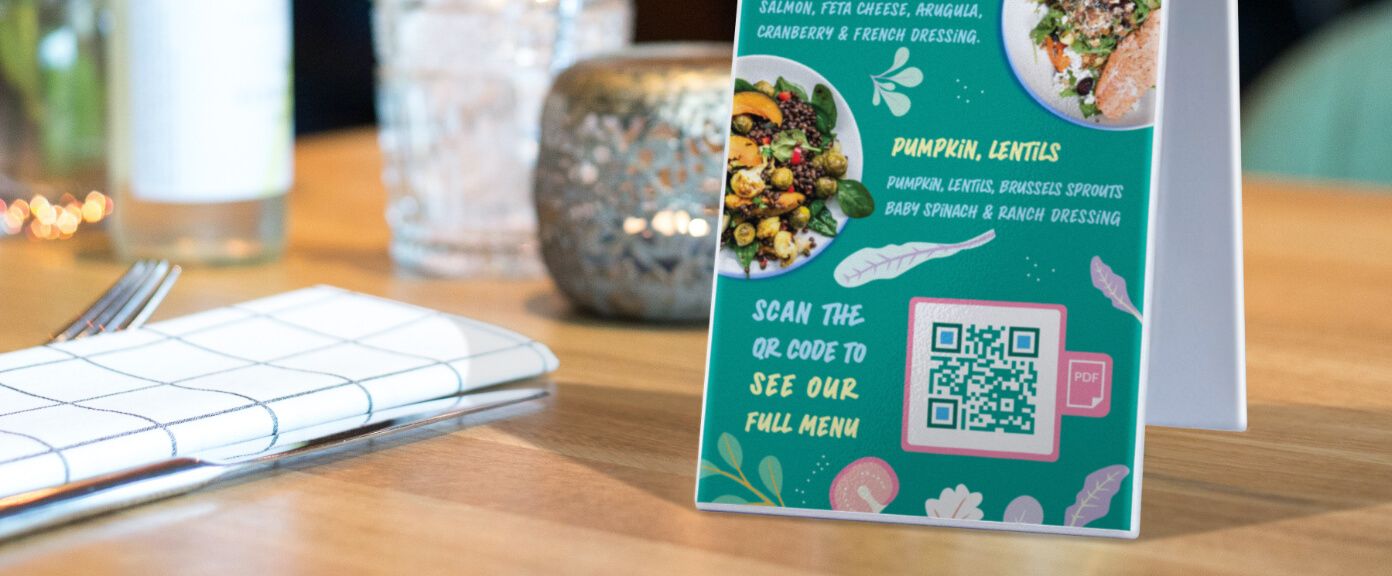 Table tent at a restaurant with a QR Code that contains a PDF version of their menu.